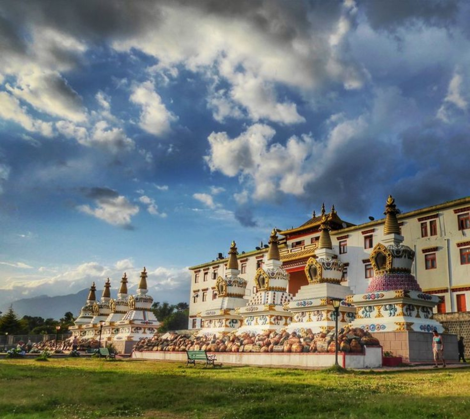 White stupas and monastery gardens beneath a blue sky