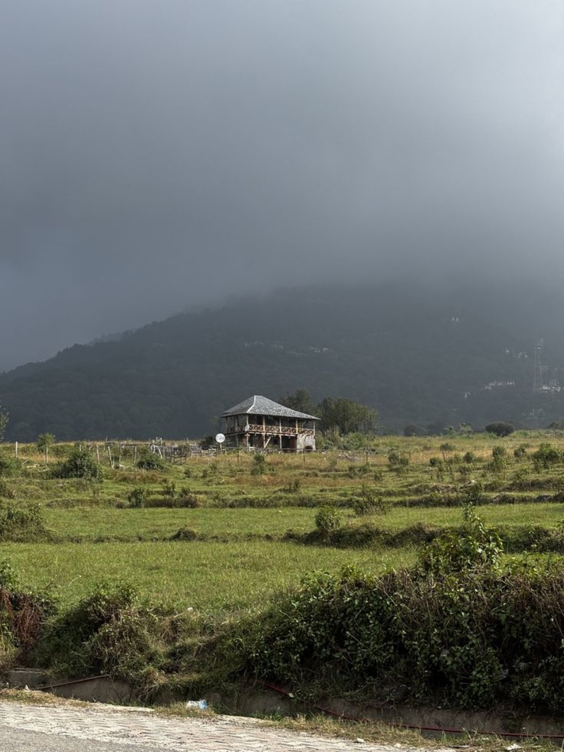 Clouds above green fields and a mountain valley